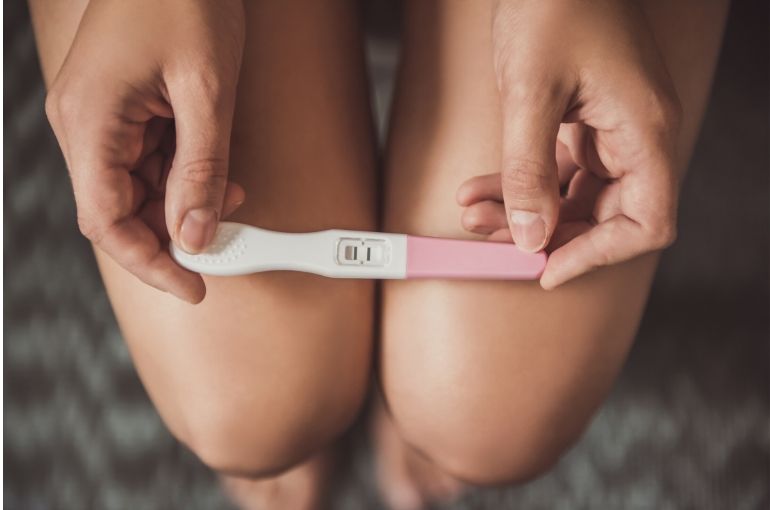 test de grossesse sur genoux d'une femme